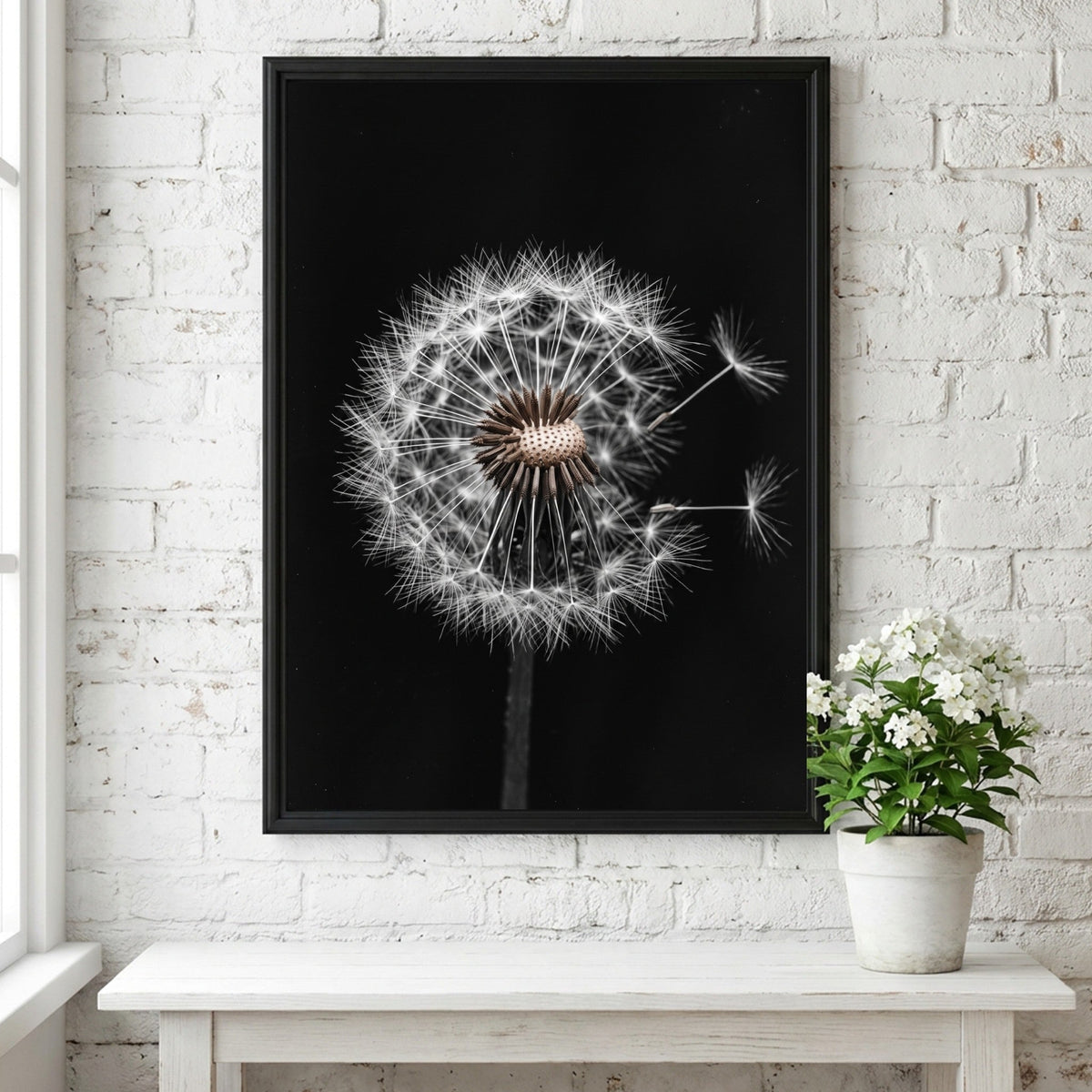Botanical wall art of a dandelion seed head with white seeds on black minimalist background