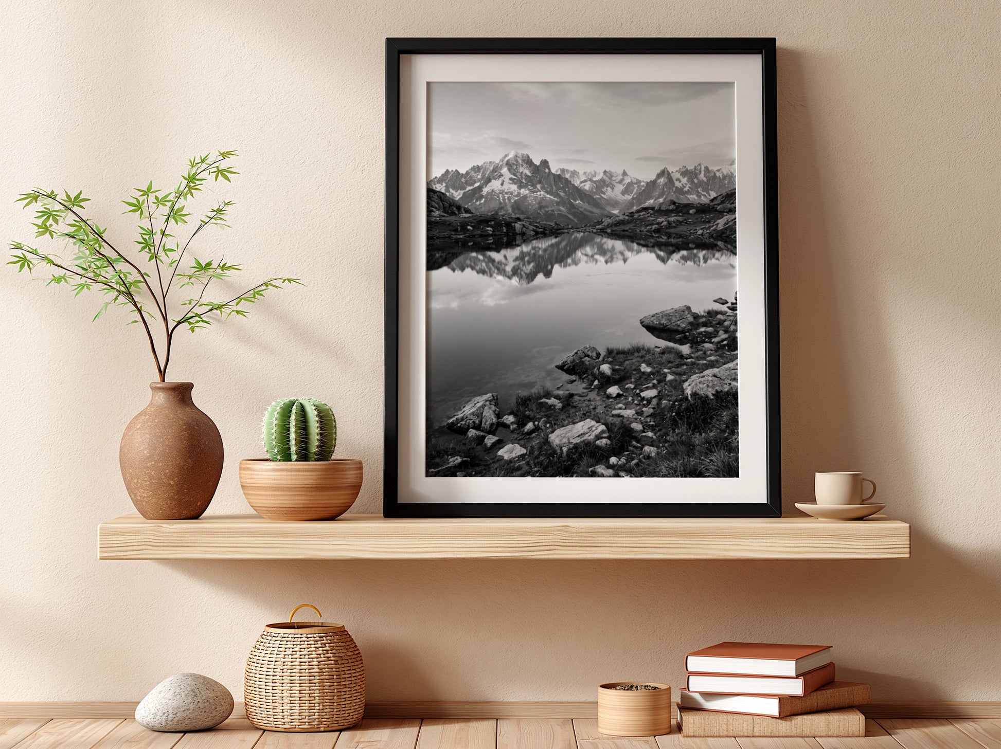 Black and white photographic wall decor showing alpine lake reflecting jagged mountain peaks and rocky shore