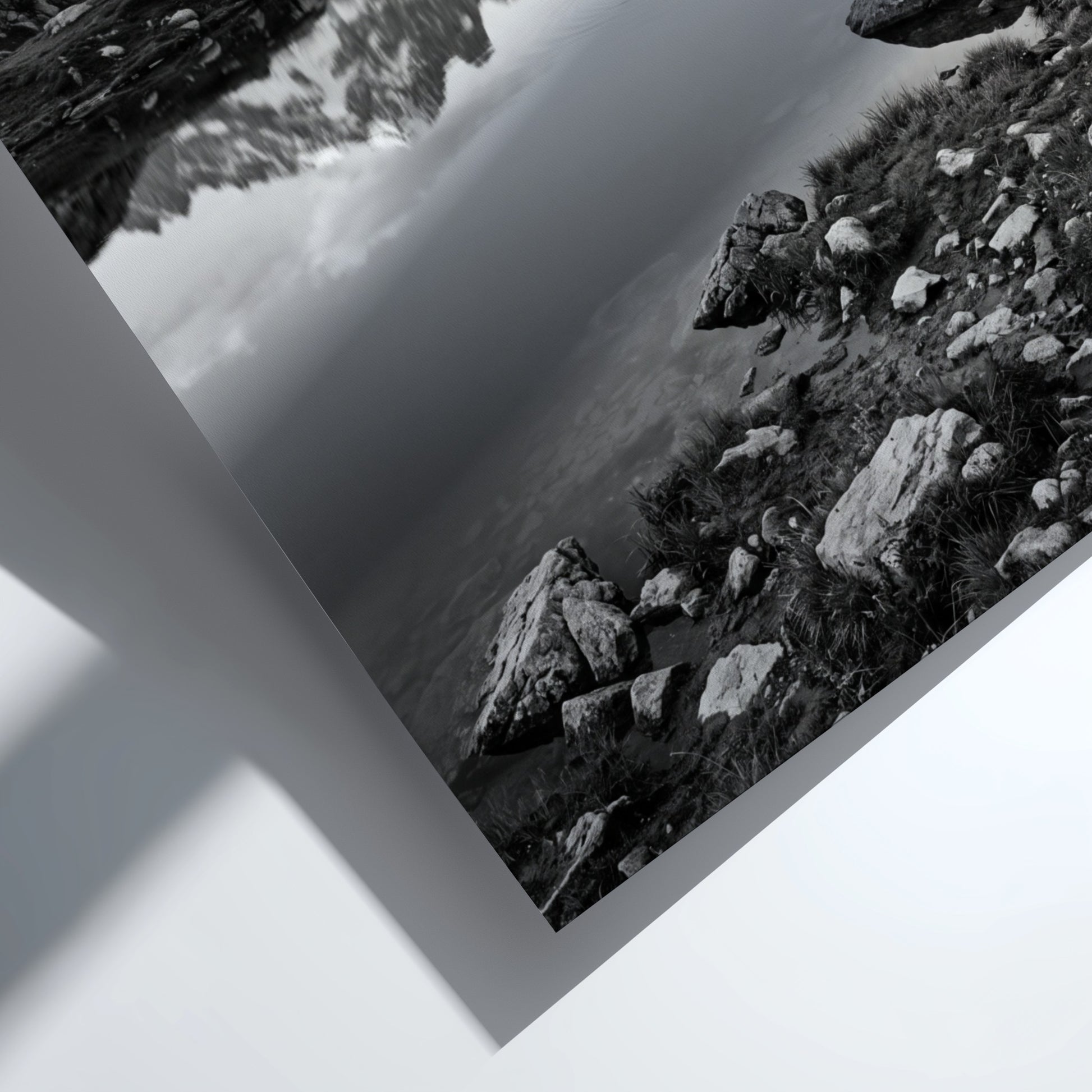 Black and white photographic wall decor showing alpine lake reflecting jagged mountain peaks and rocky shore