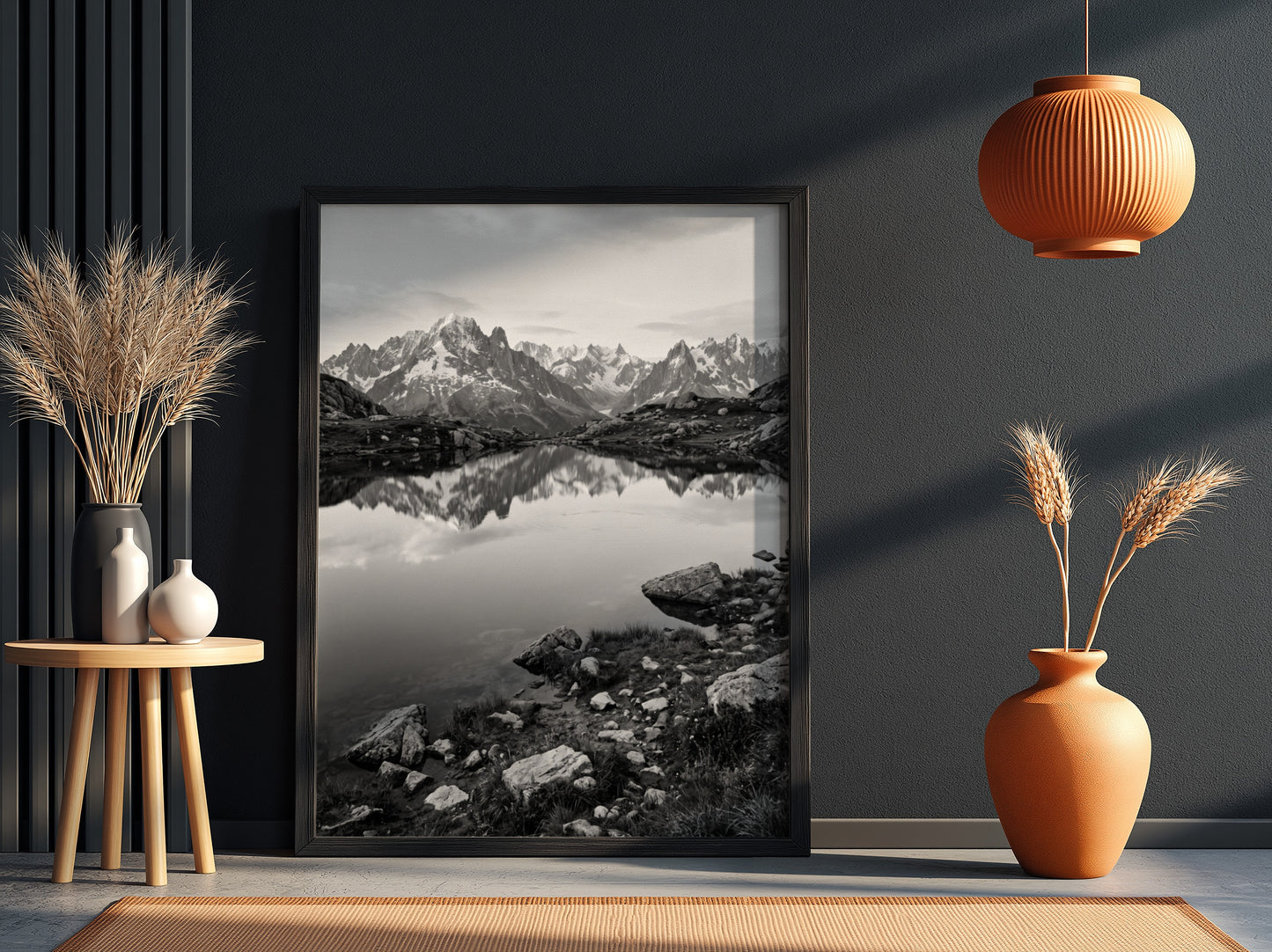 Black and white photographic wall decor showing alpine lake reflecting jagged mountain peaks and rocky shore