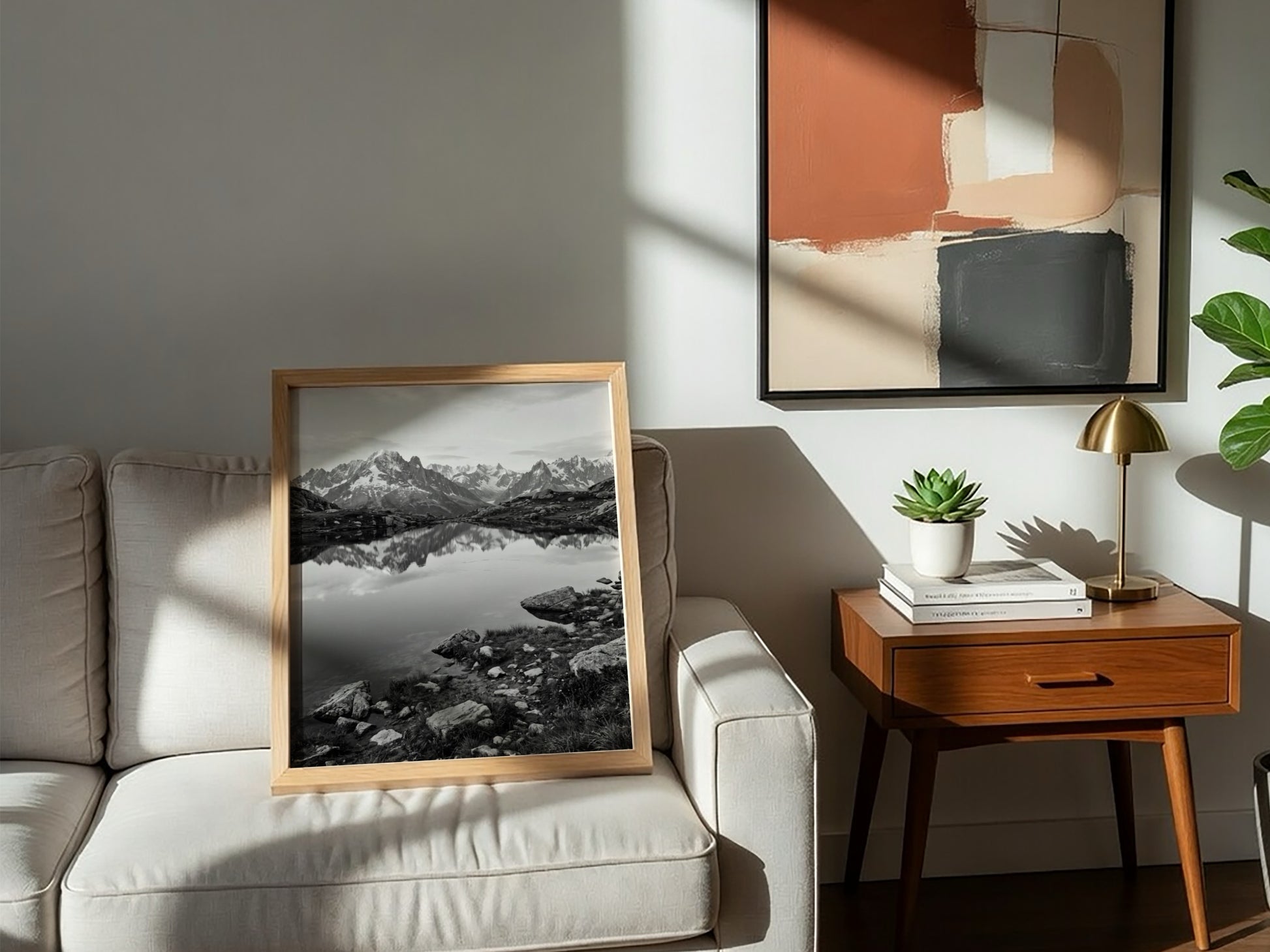 Black and white photographic wall decor showing alpine lake reflecting jagged mountain peaks and rocky shore