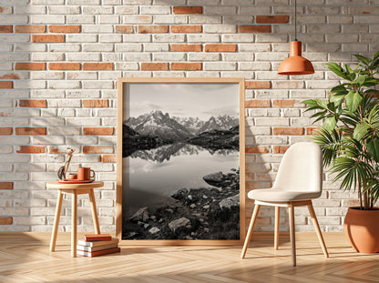 Black and white photographic wall decor showing alpine lake reflecting jagged mountain peaks and rocky shore