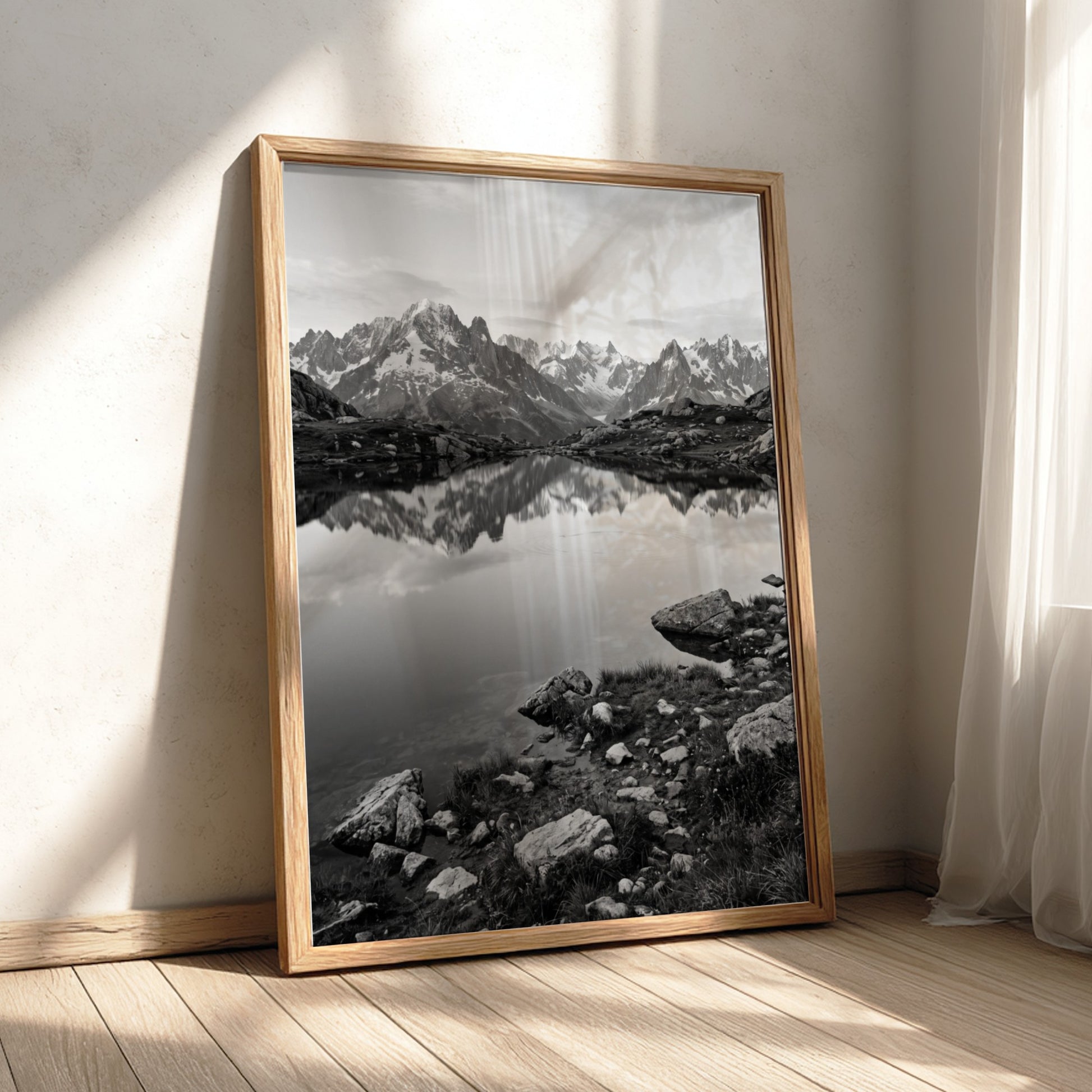 Black and white photographic wall decor showing alpine lake reflecting jagged mountain peaks and rocky shore