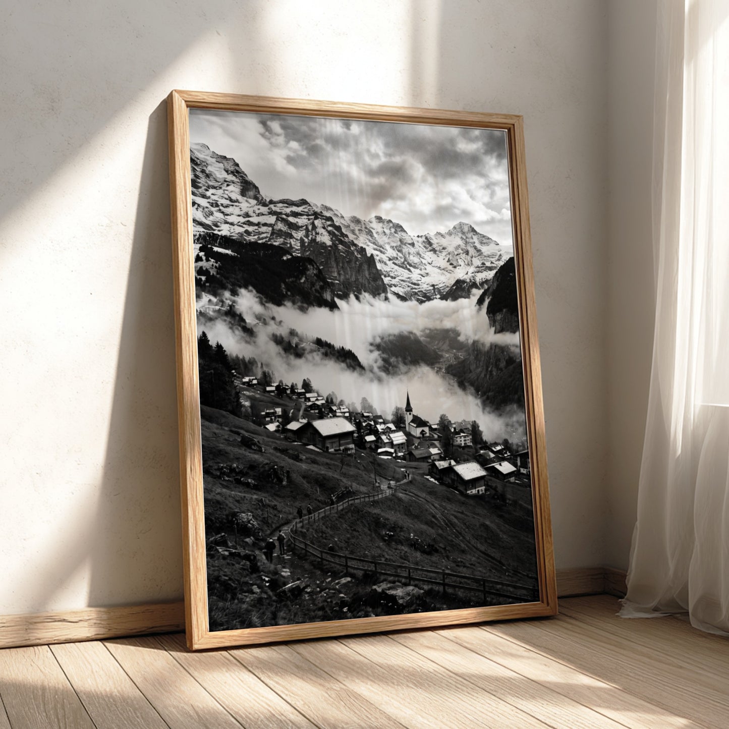Black and white wall decor showing alpine village with snow-covered mountains and misty valley