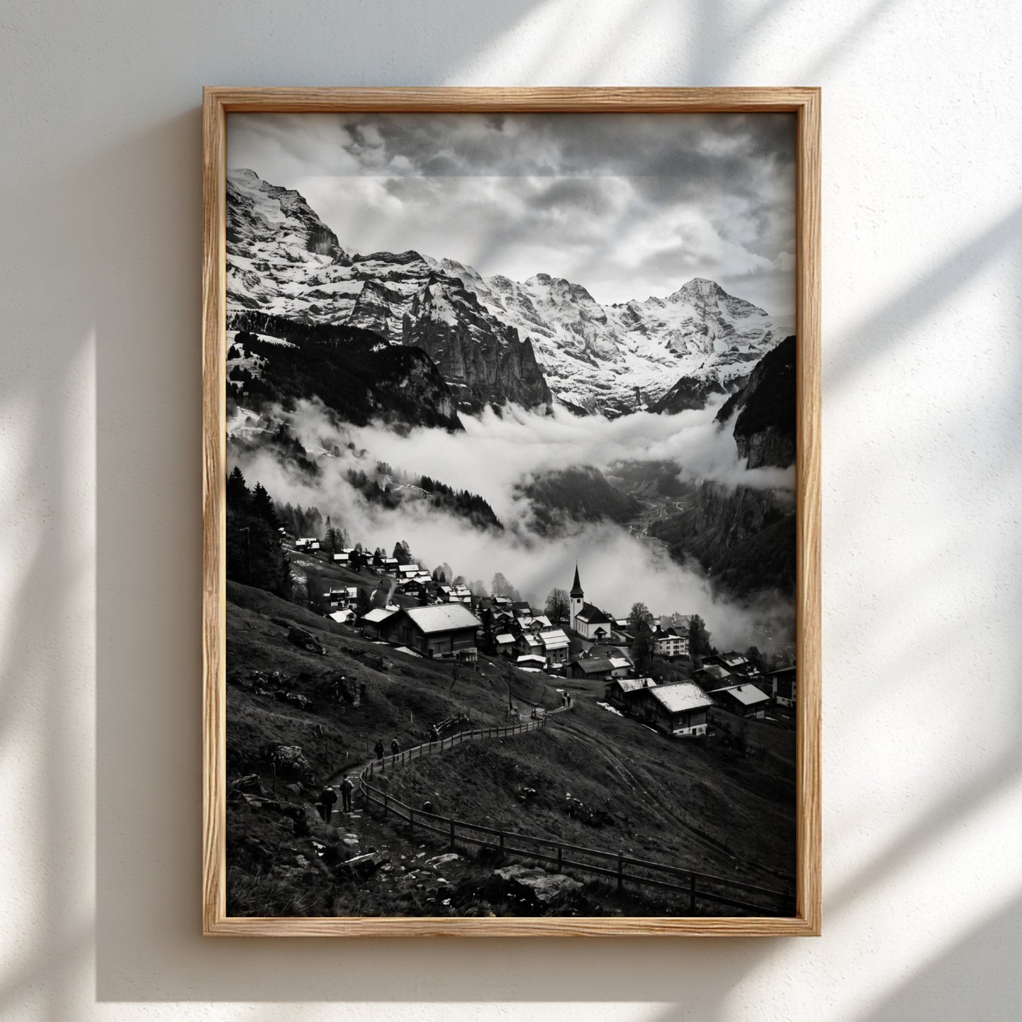 Black and white wall decor showing alpine village with snow-covered mountains and misty valley