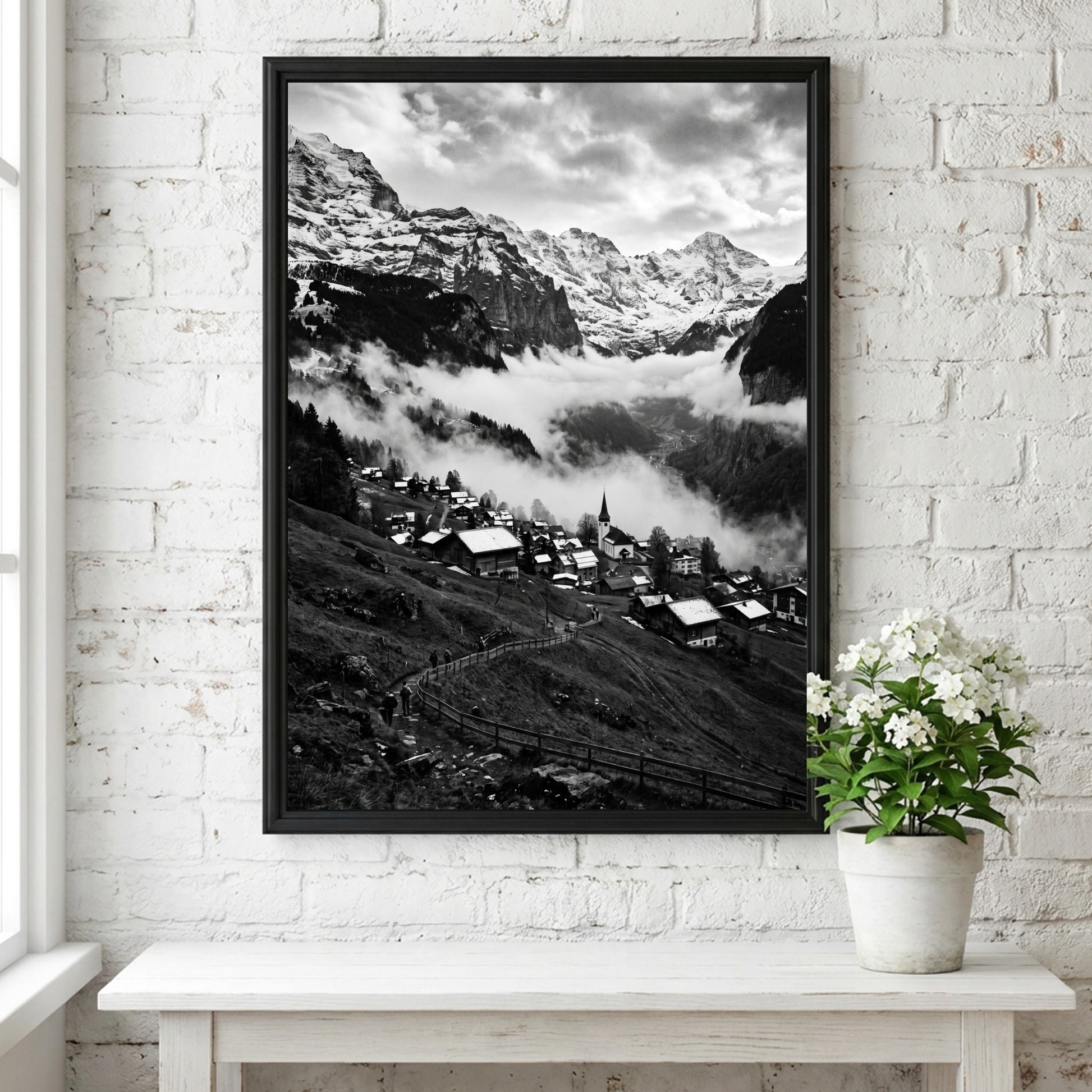 Black and white wall decor showing alpine village with snow-covered mountains and misty valley