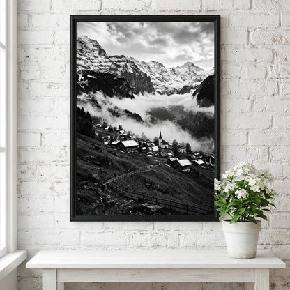 Black and white wall decor showing alpine village with snow-covered mountains and misty valley