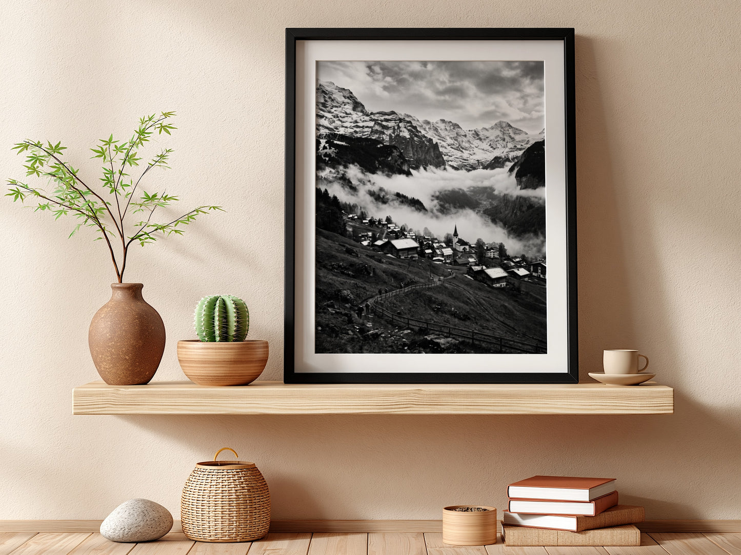 Black and white wall decor showing alpine village with snow-covered mountains and misty valley