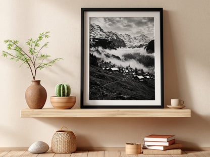 Black and white wall decor showing alpine village with snow-covered mountains and misty valley