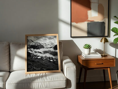 Black and white wall decor showing alpine village with snow-covered mountains and misty valley