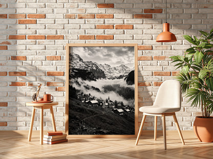 Black and white wall decor showing alpine village with snow-covered mountains and misty valley