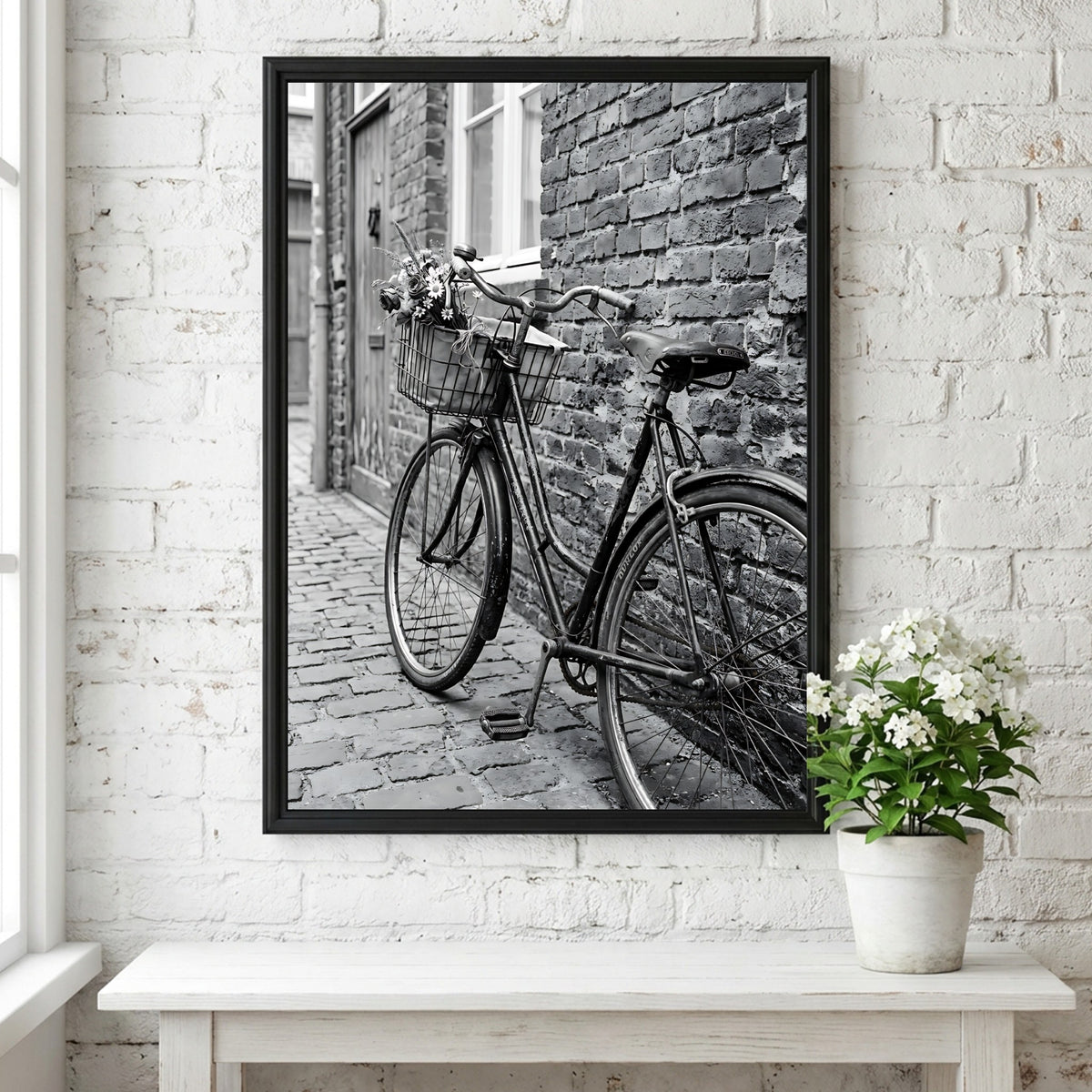 Black and white poster of vintage bicycle leaning against textured brick wall on cobblestone street