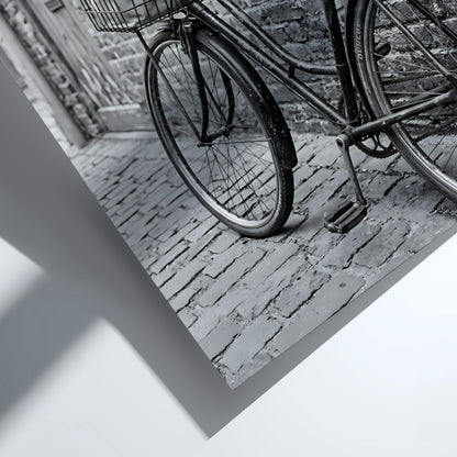 Black and white poster of vintage bicycle leaning against textured brick wall on cobblestone street