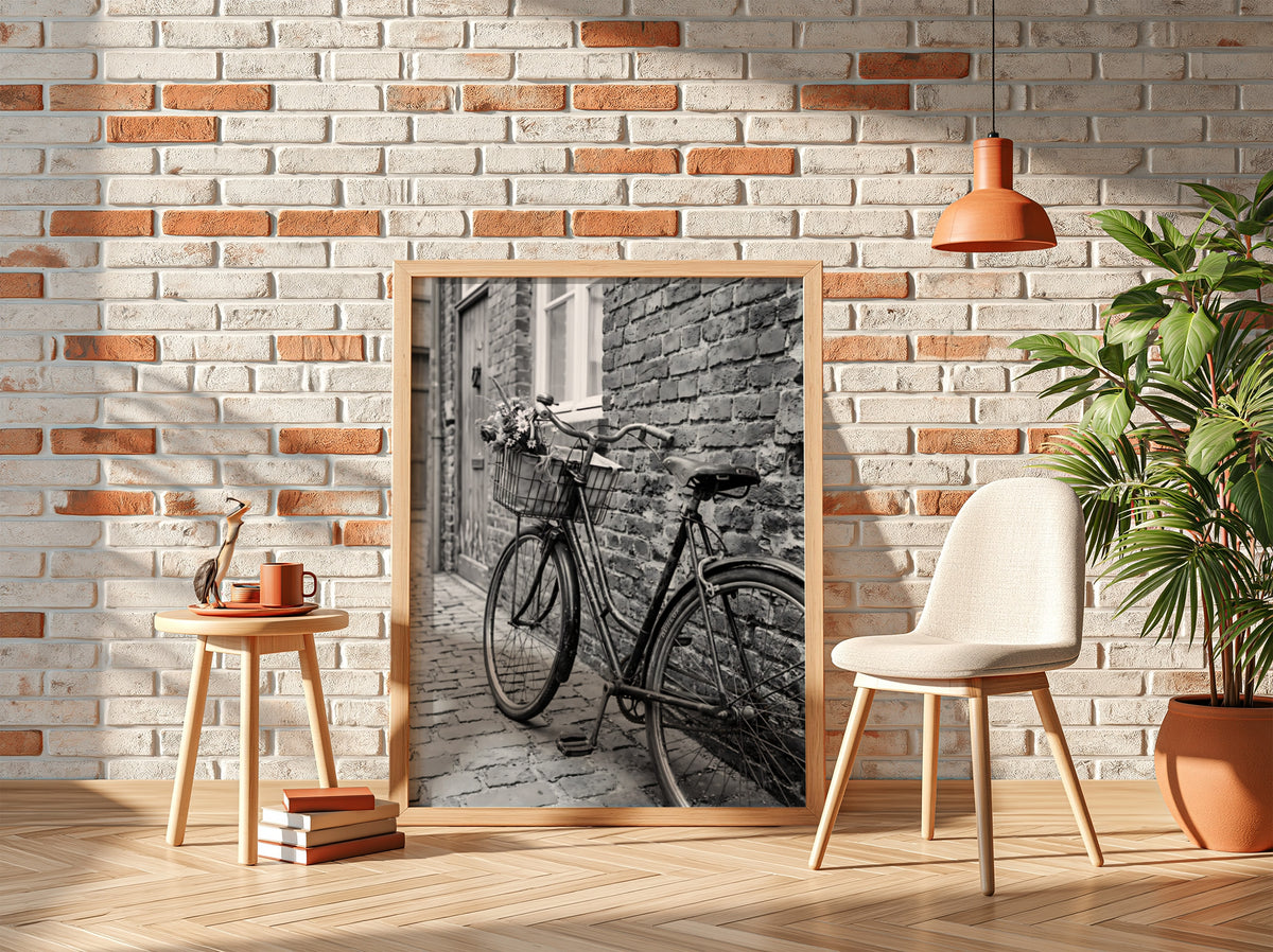 Black and white poster of vintage bicycle leaning against textured brick wall on cobblestone street