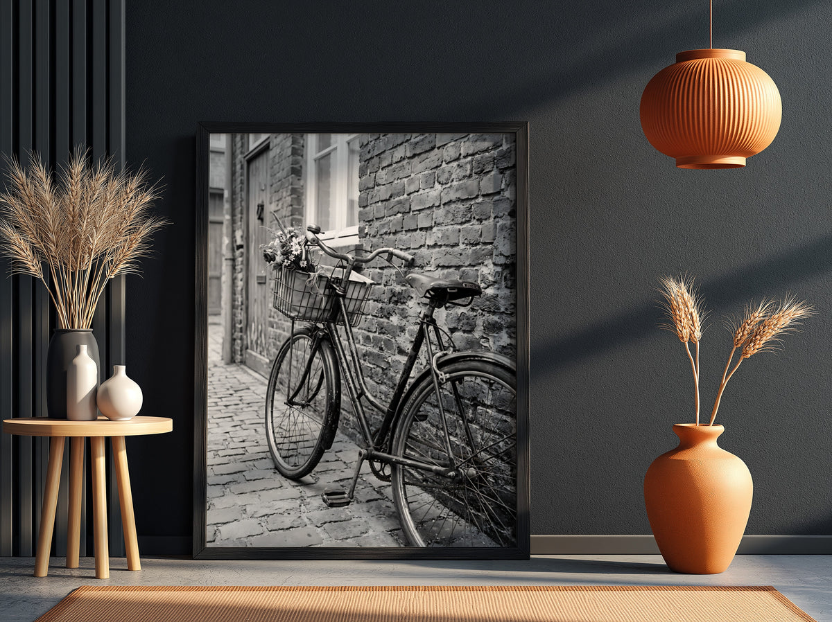 Black and white poster of vintage bicycle leaning against textured brick wall on cobblestone street