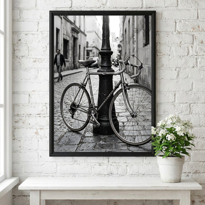 Black and white wall decor featuring vintage bicycle parked against ornate lamppost on cobblestone street
