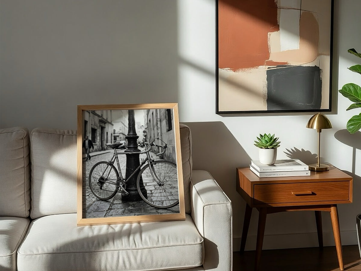 Black and white wall decor featuring vintage bicycle parked against ornate lamppost on cobblestone street