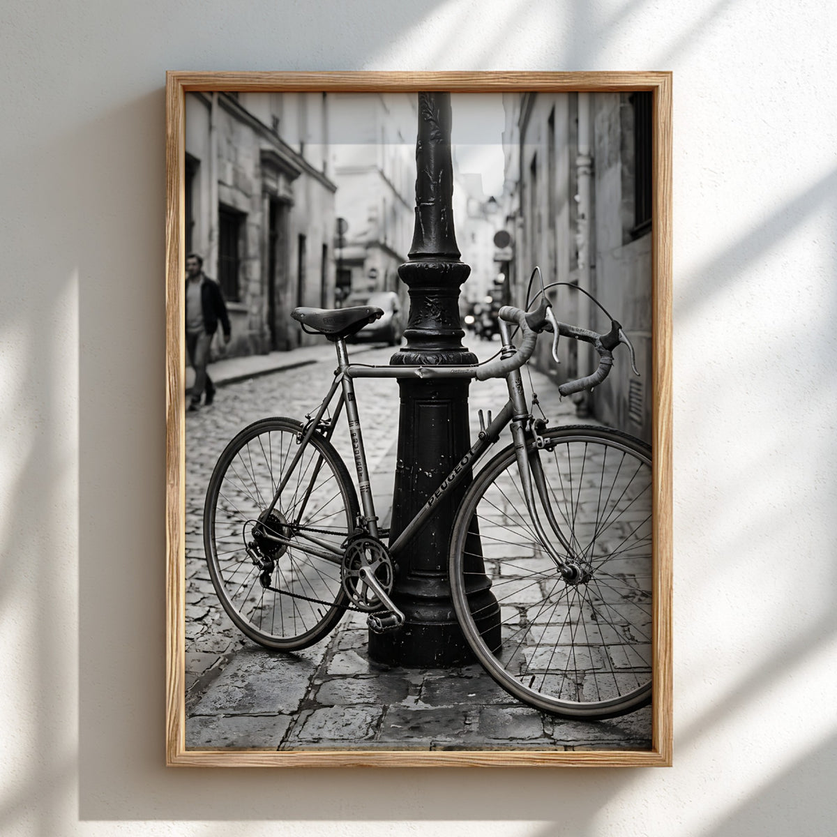 Black and white wall decor featuring vintage bicycle parked against ornate lamppost on cobblestone street