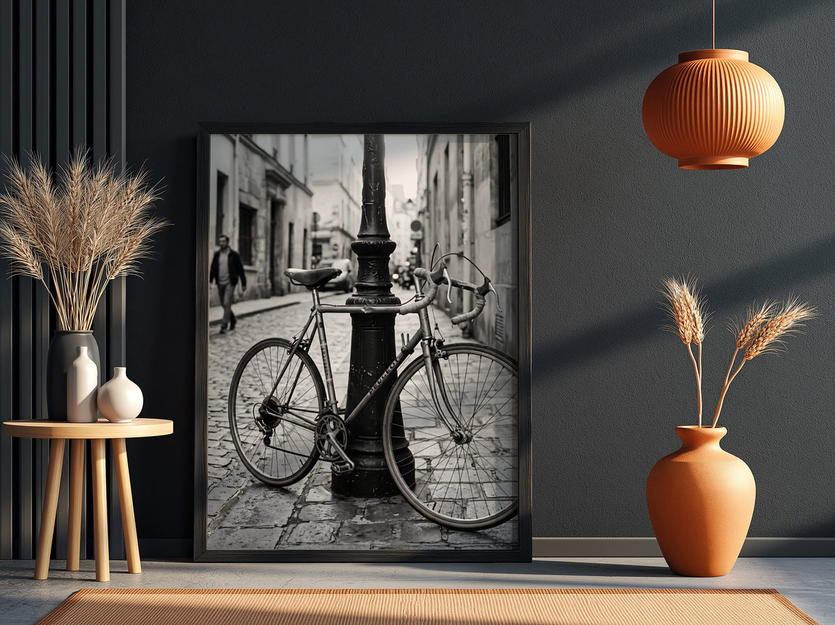 Black and white wall decor featuring vintage bicycle parked against ornate lamppost on cobblestone street
