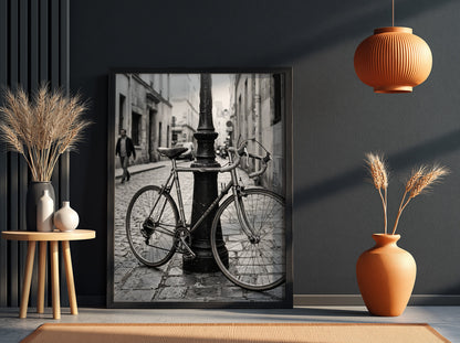 Black and white wall decor featuring vintage bicycle parked against ornate lamppost on cobblestone street