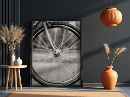 Black and white wall art of bicycle wheel in motion with blurred spokes and sharp mechanical details