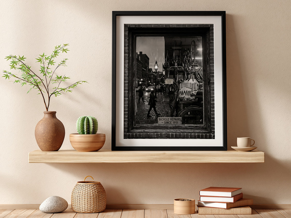 Black and white bicycle repairs shop poster with vintage bicycles and tools seen through window