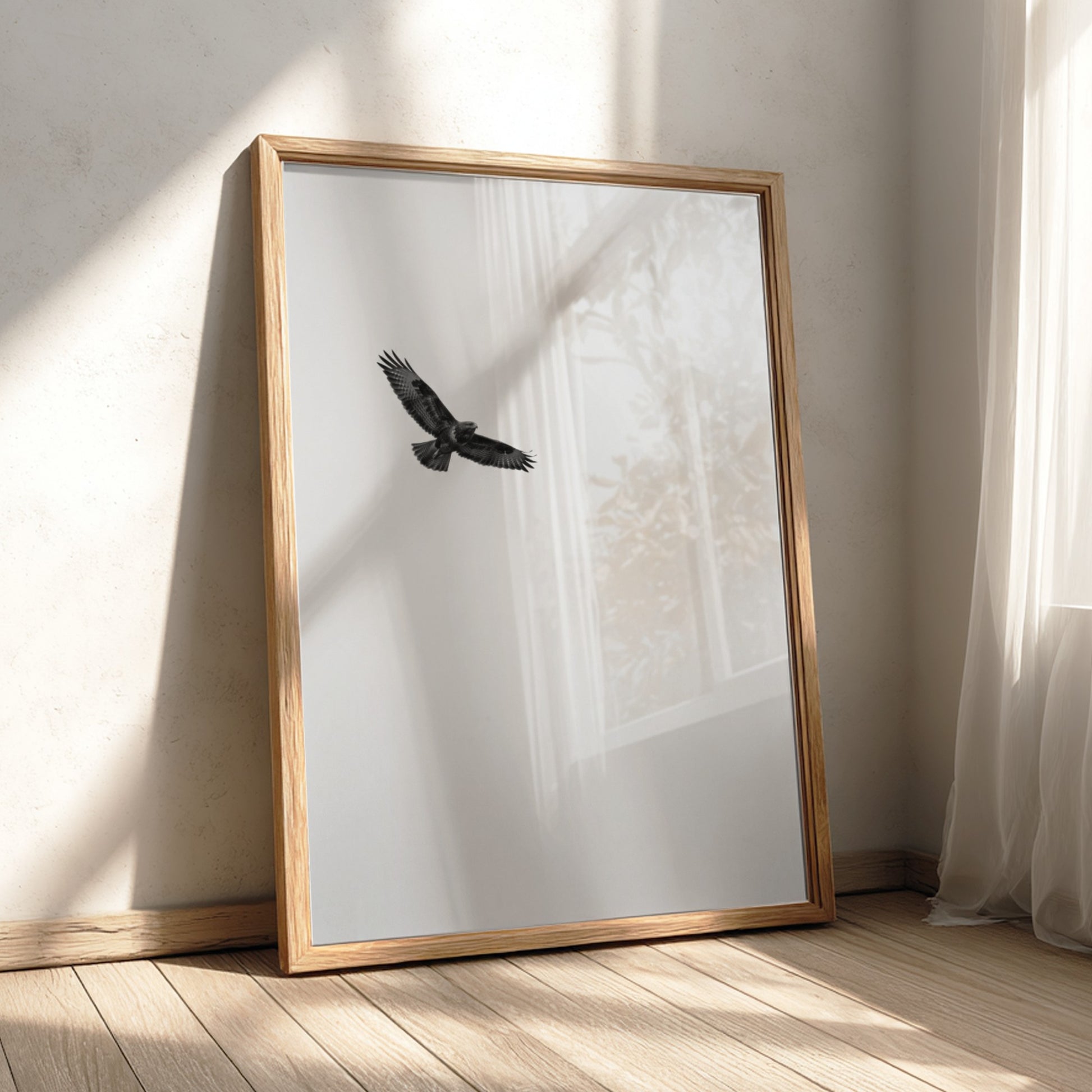 Framed wall decor featuring a black bird in flight against a pale sky with natural wood frame