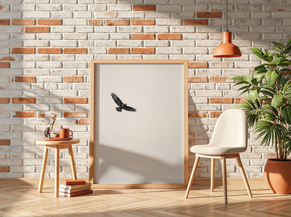 Framed wall decor featuring a black bird in flight against a pale sky with natural wood frame