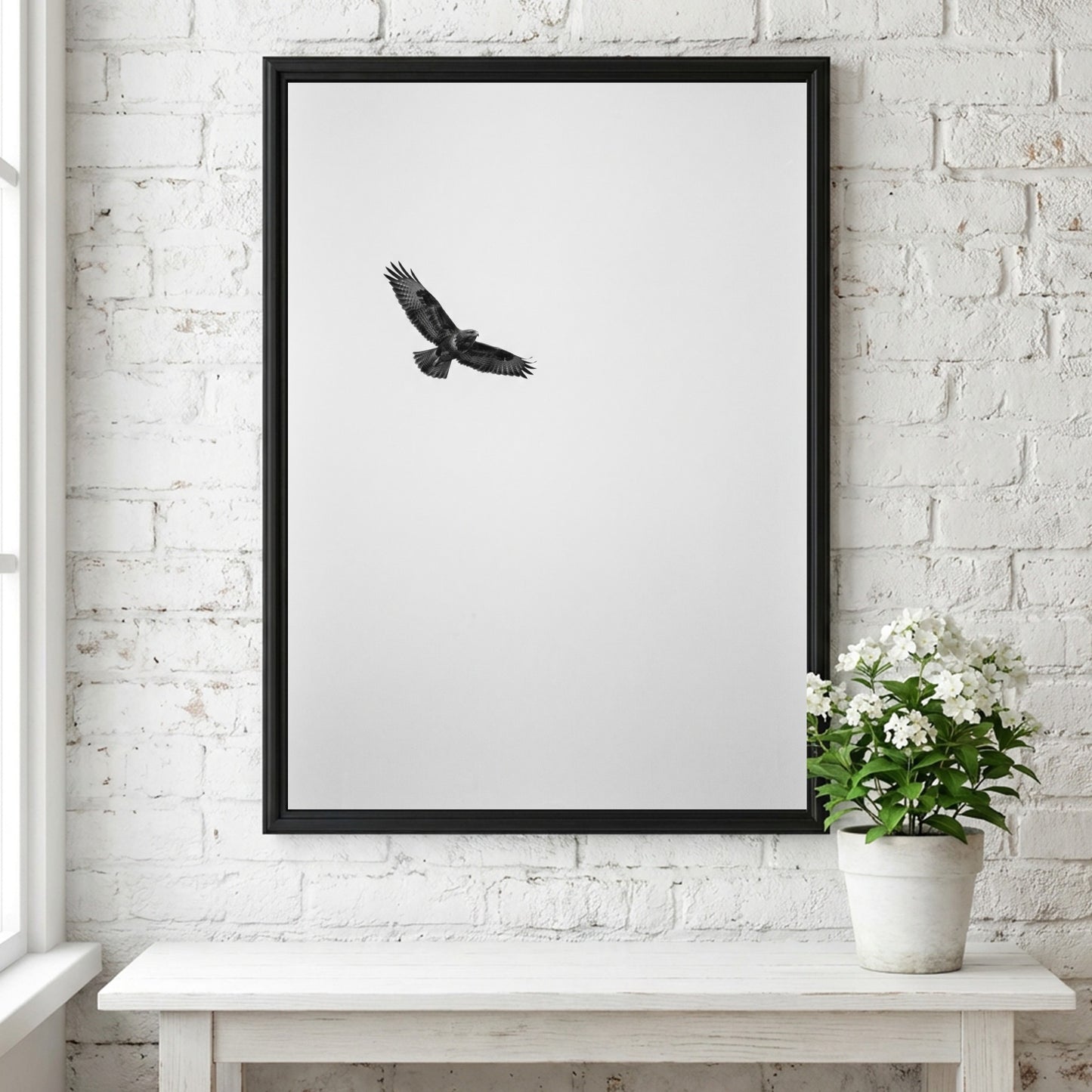 Framed wall decor featuring a black bird in flight against a pale sky with natural wood frame