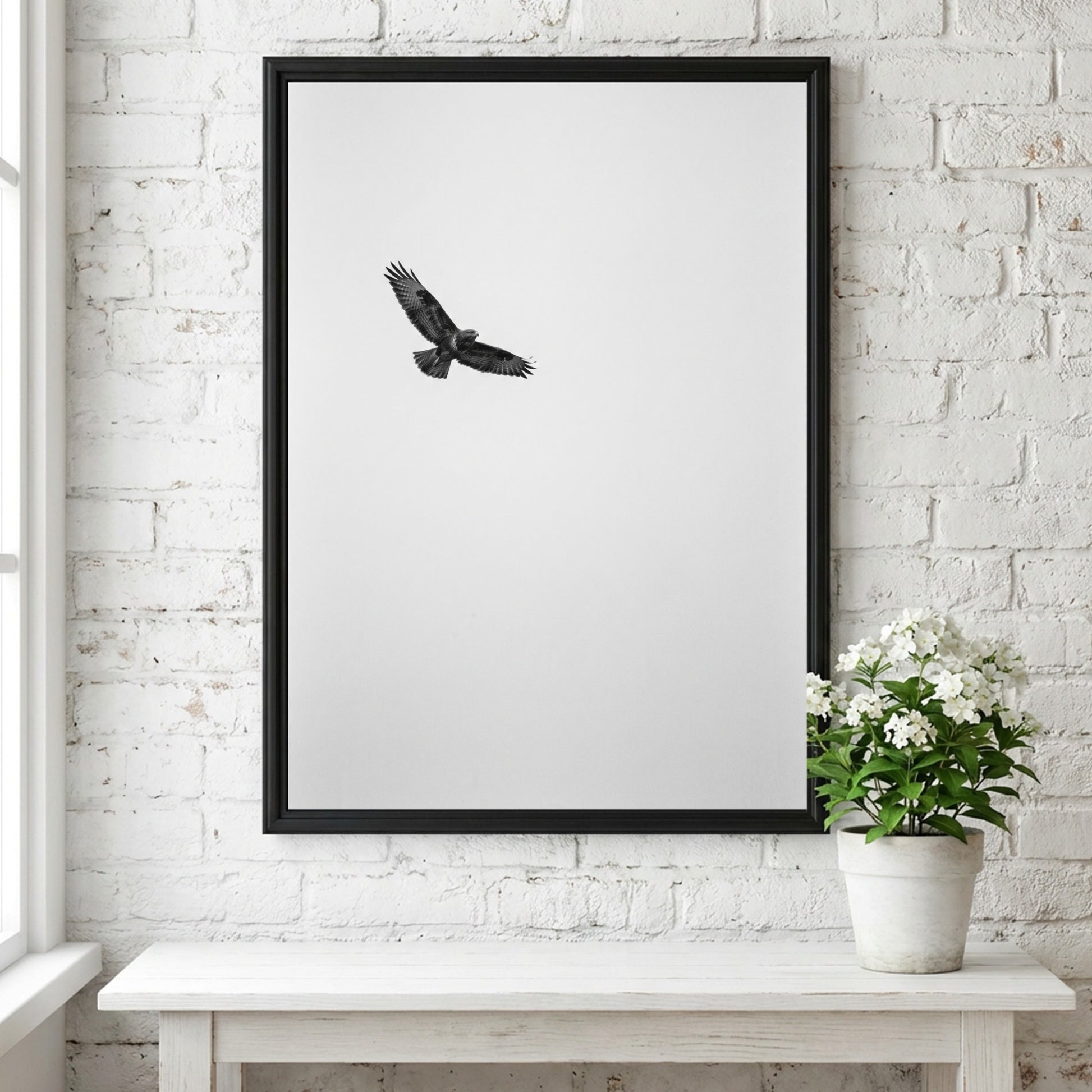 Framed wall decor featuring a black bird in flight against a pale sky with natural wood frame