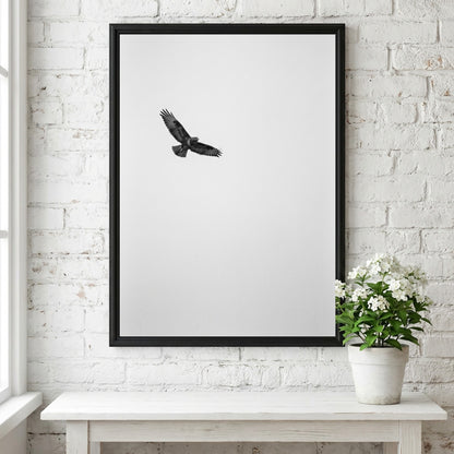 Framed wall decor featuring a black bird in flight against a pale sky with natural wood frame