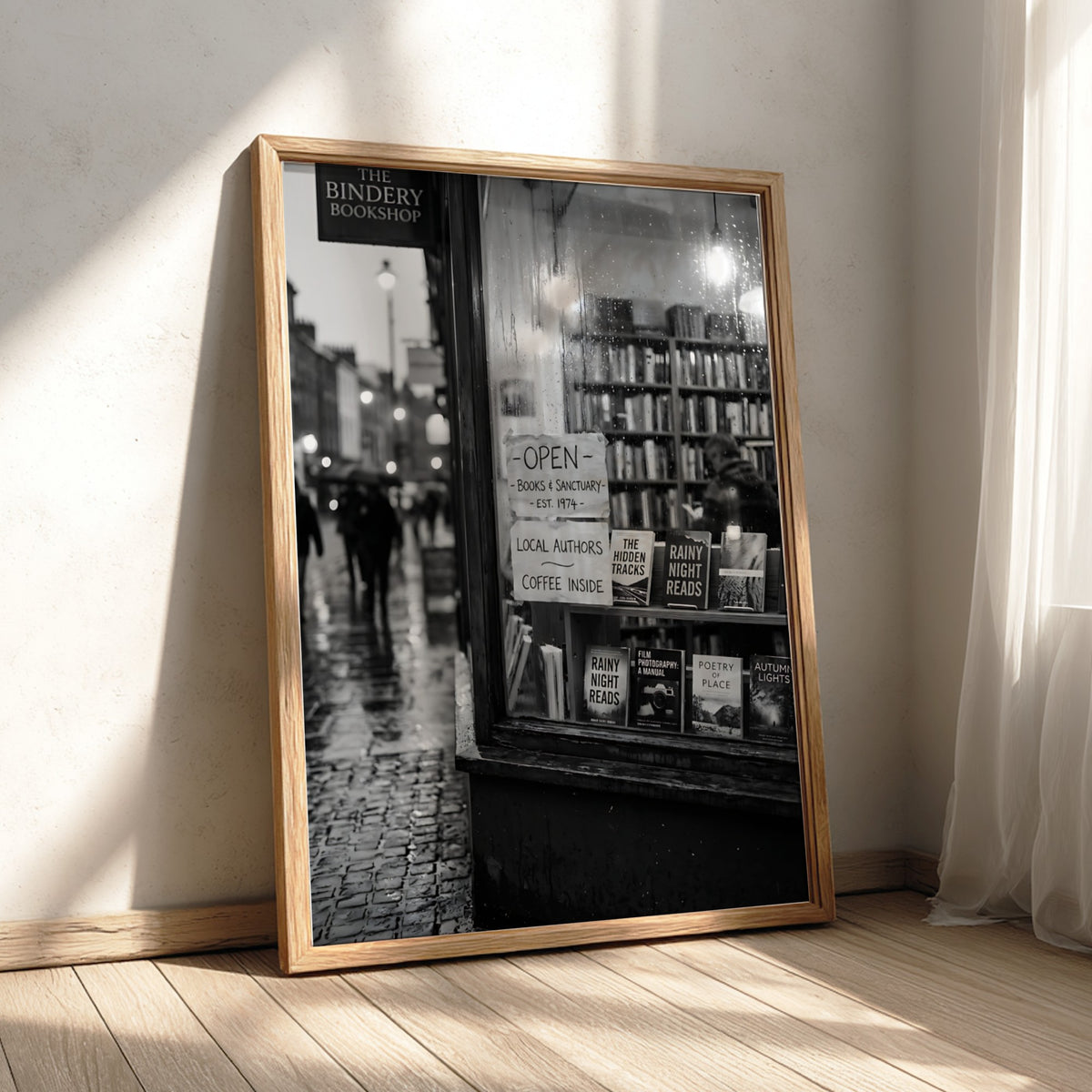 Black and white photographic wall decor showing a rainy evening bookshop window with books and reflections