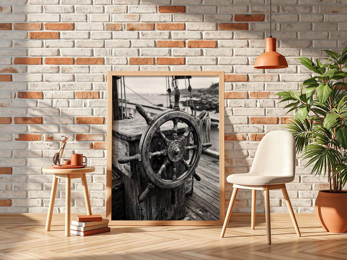 Black and white wall decor showing brass ship wheel on wooden deck with nautical ropes