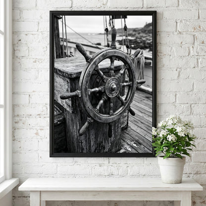 Black and white wall decor showing brass ship wheel on wooden deck with nautical ropes