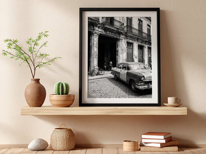 Black and white poster of vintage car parked on Havana street with colonial building and cobblestones