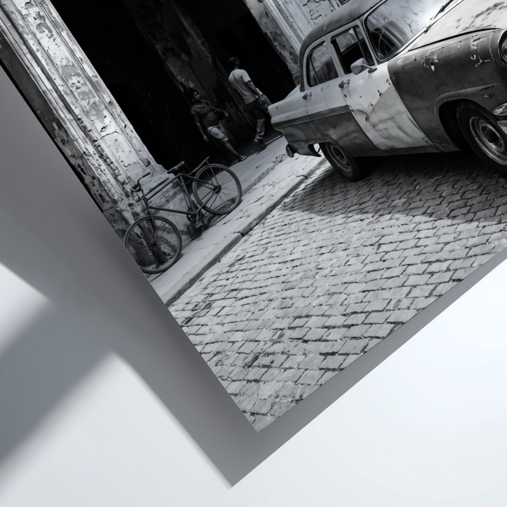 Black and white poster of vintage car parked on Havana street with colonial building and cobblestones