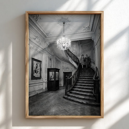 Black and white cinema lobby poster with sweeping staircase and chandelier in vintage style