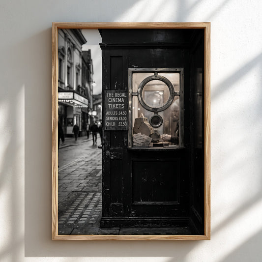 black and white vintage wall decor of cinema ticket booth with circular window and street scene