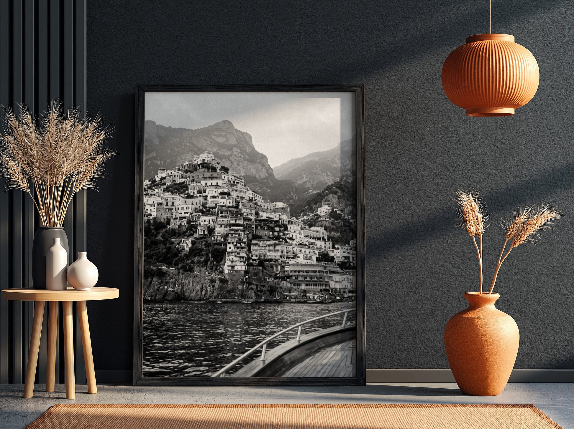 Black and white poster of cliffside village viewed from boat with coastal houses and mountain background