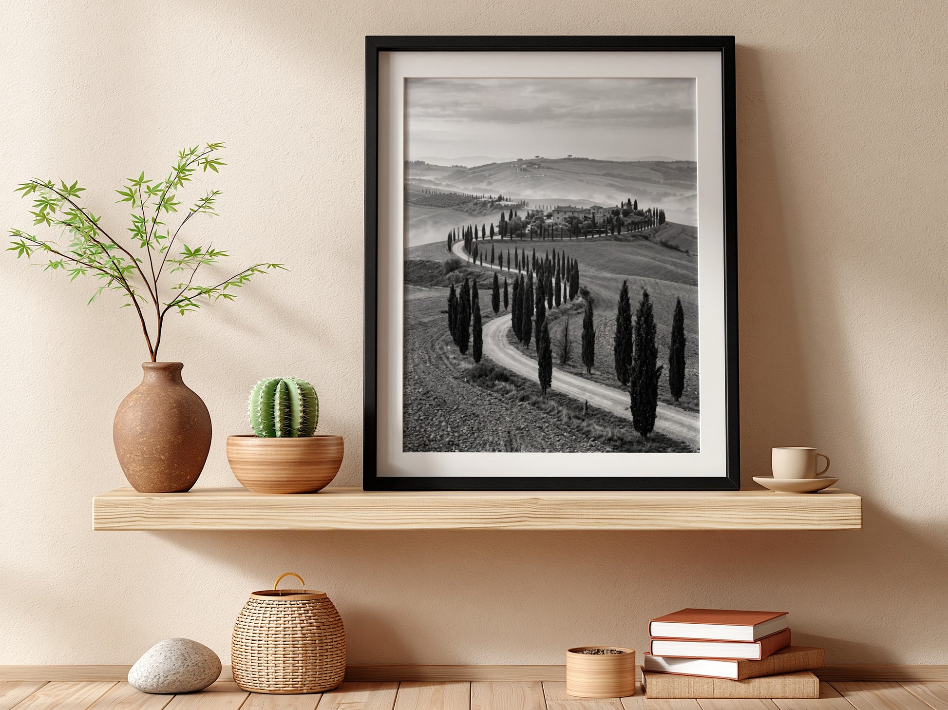 Black and white wall decor featuring tall cypress trees lining winding road on rolling hills