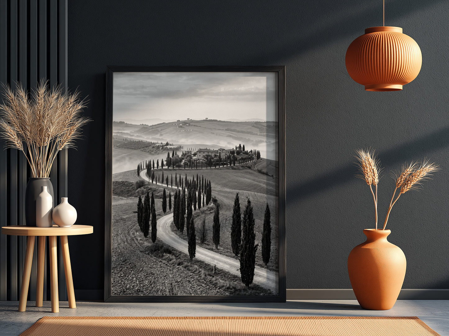Black and white wall decor featuring tall cypress trees lining winding road on rolling hills