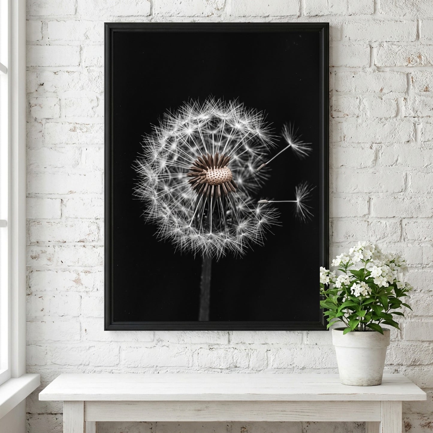 Botanical wall art of a dandelion seed head with white seeds on black minimalist background