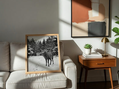 black and white nature wall decor showing deer standing in snowy forest clearing with pine trees
