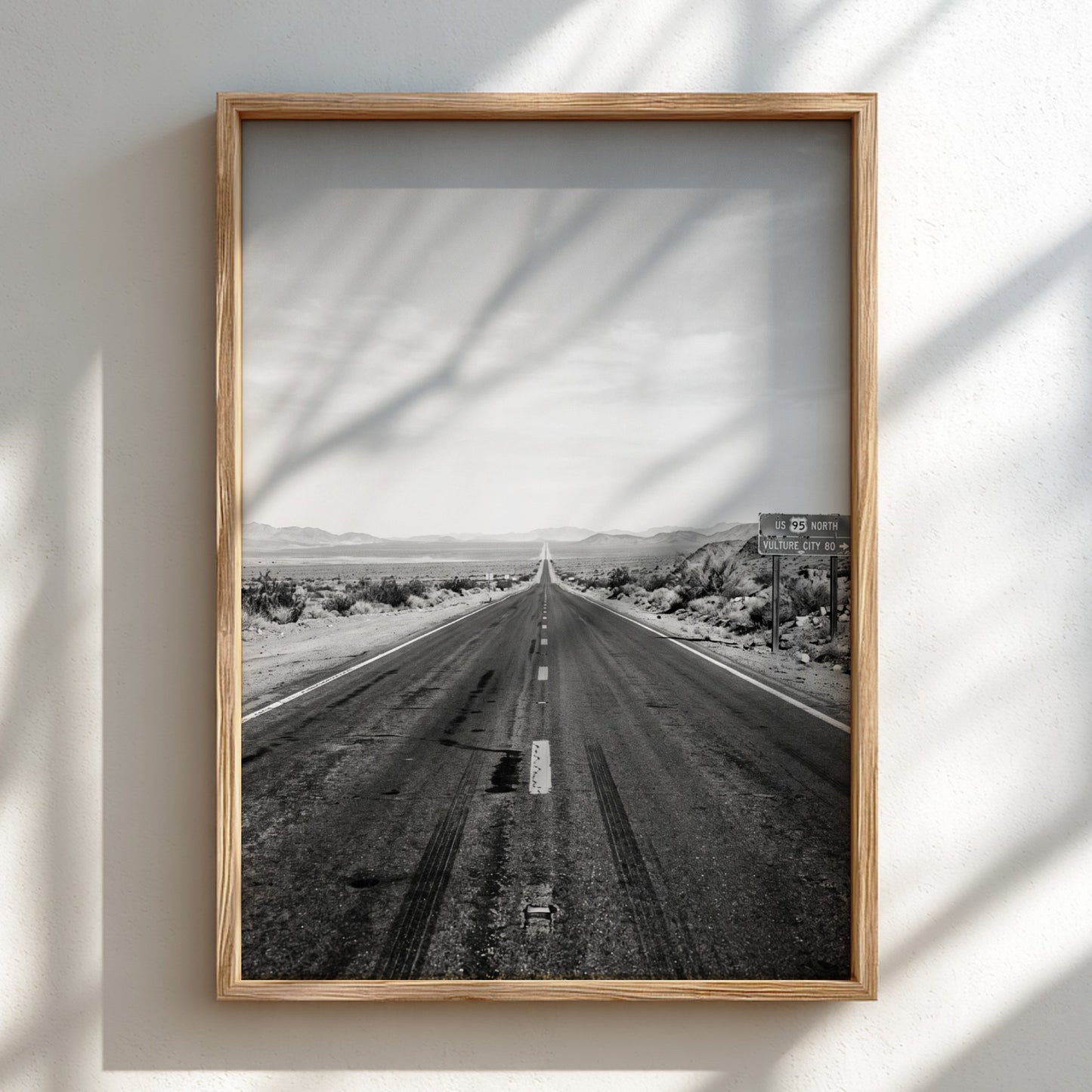 Wall poster of black and white desert highway stretching to horizon with mountains and open landscape