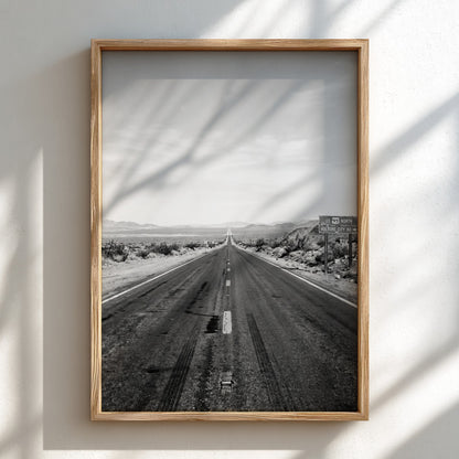 Wall poster of black and white desert highway stretching to horizon with mountains and open landscape