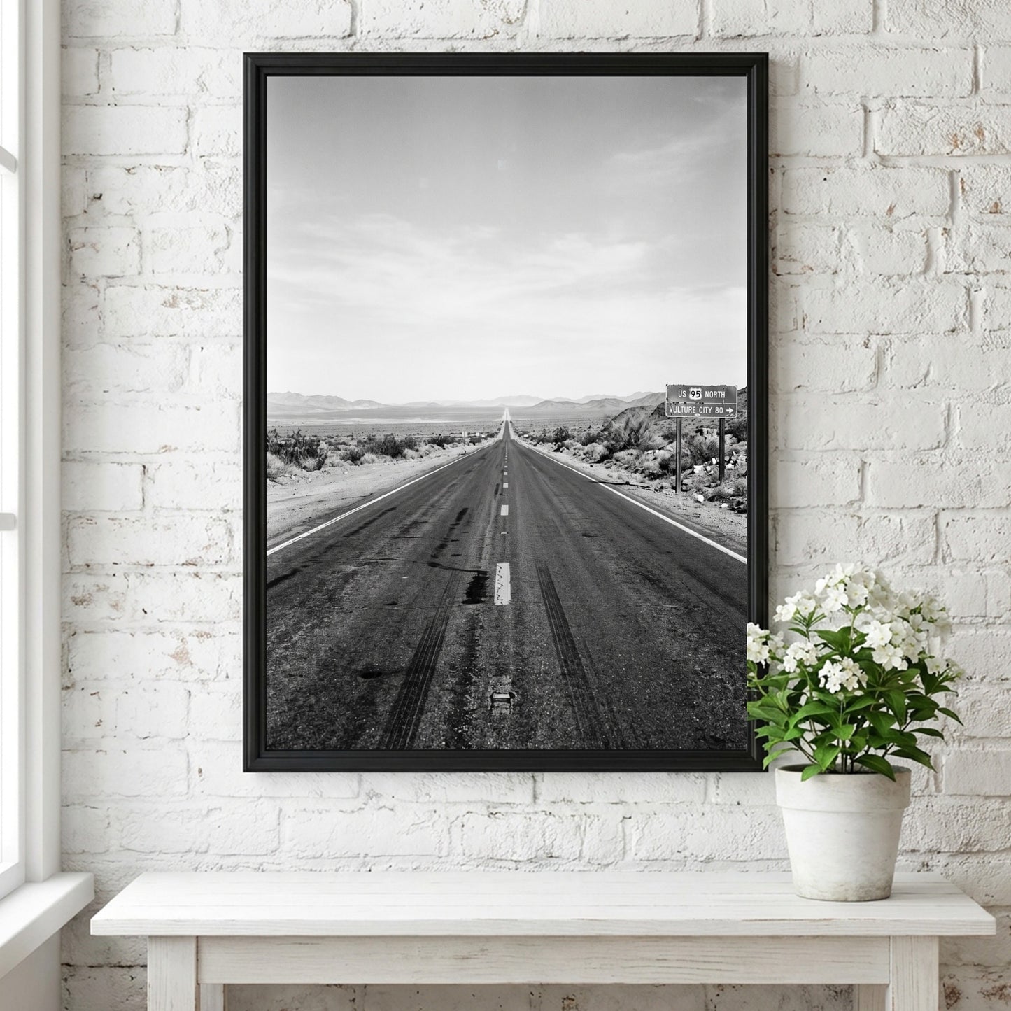 Wall poster of black and white desert highway stretching to horizon with mountains and open landscape