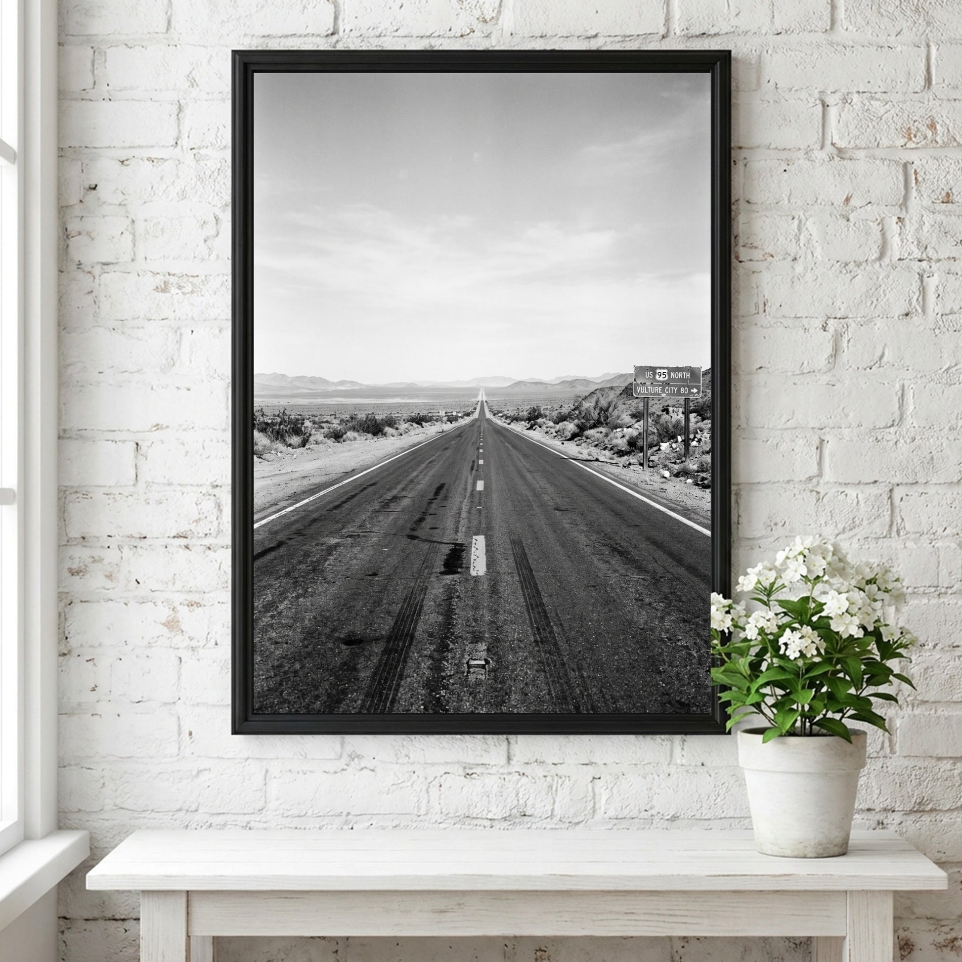 Wall poster of black and white desert highway stretching to horizon with mountains and open landscape