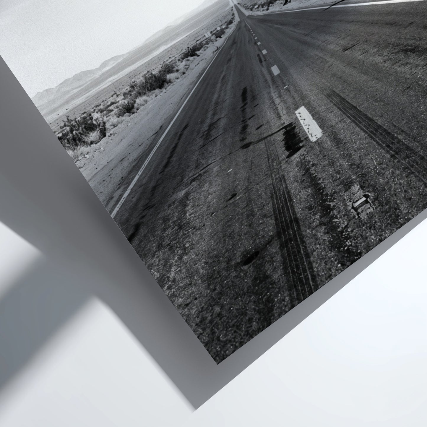 Wall poster of black and white desert highway stretching to horizon with mountains and open landscape
