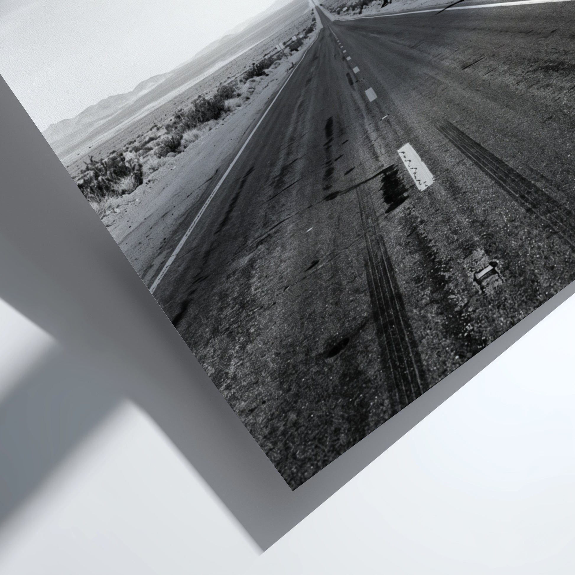 Wall poster of black and white desert highway stretching to horizon with mountains and open landscape