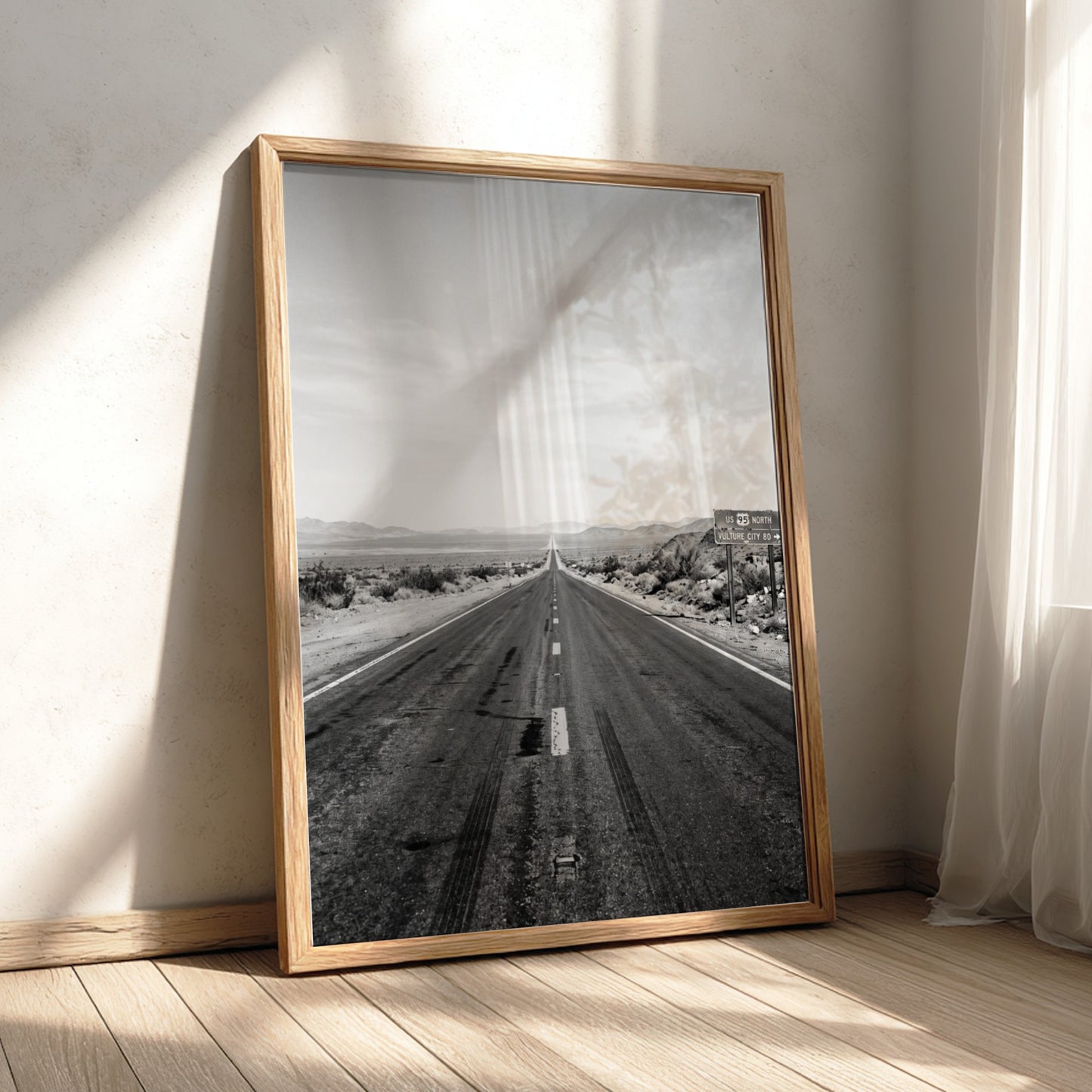 Wall poster of black and white desert highway stretching to horizon with mountains and open landscape
